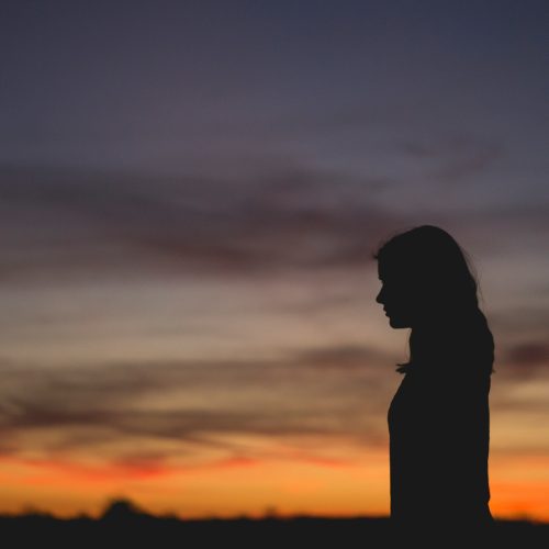 woman standing alone against sky background